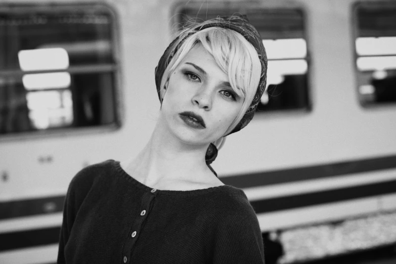 a woman stands in front of a train