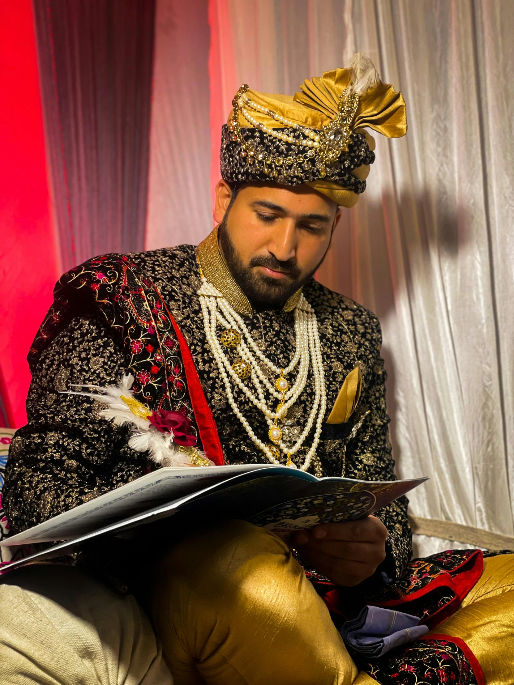 man in an oriental dress reading a book