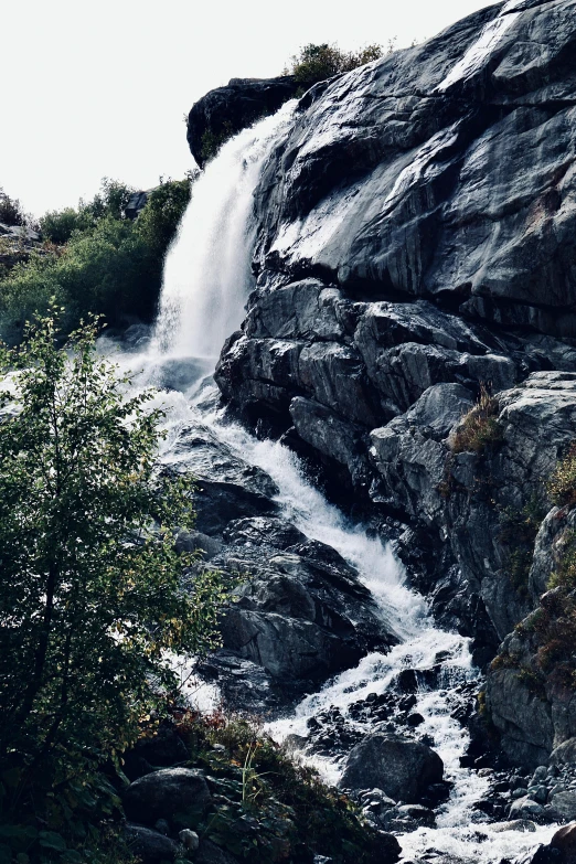 a large waterfall pouring into a river between two rocks