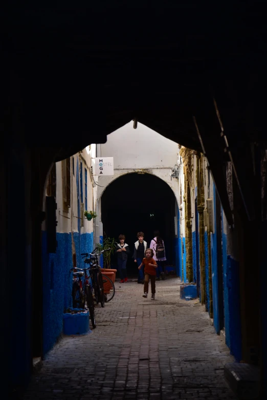 people walking down a very dark and alley way