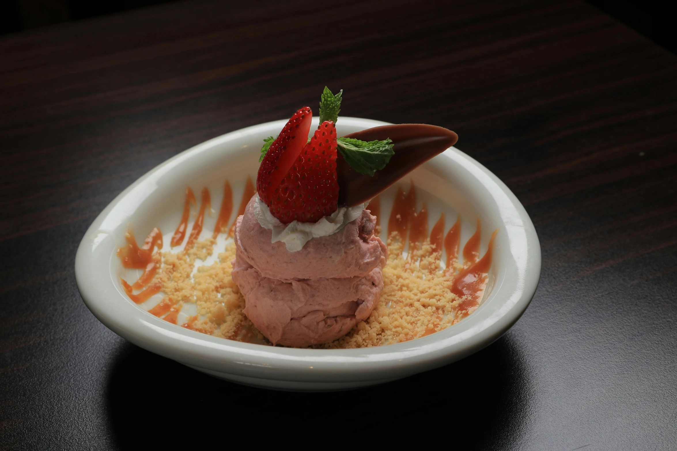 a small dish with a straw and a strawberry garnish