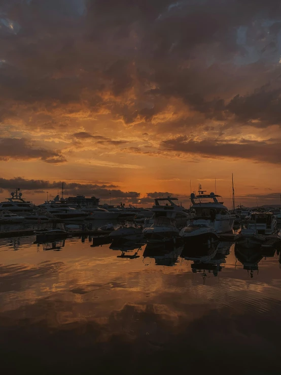 the sun is rising behind a large crowd of boats