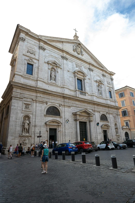 people in front of a white stone building