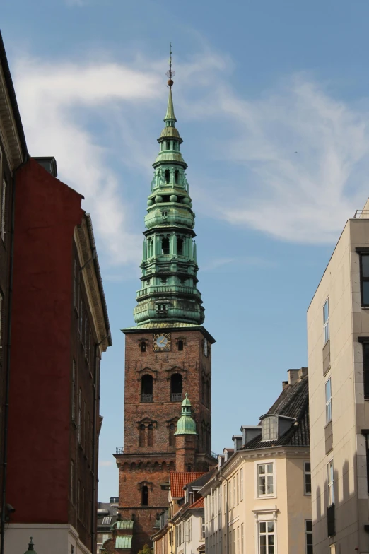 an old tower stands near other buildings