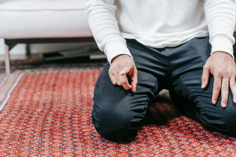 man in a white sweater tying up his shoelace