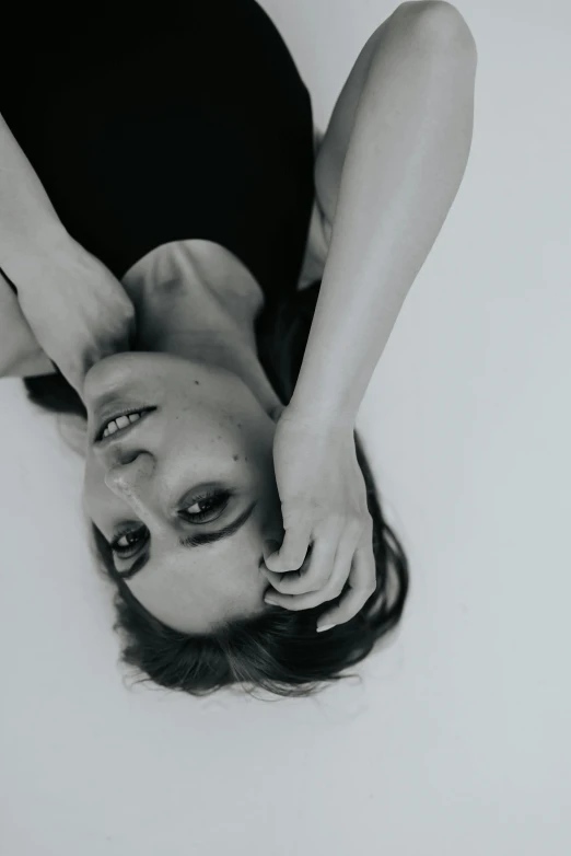 a woman with her hands on her head is laying down