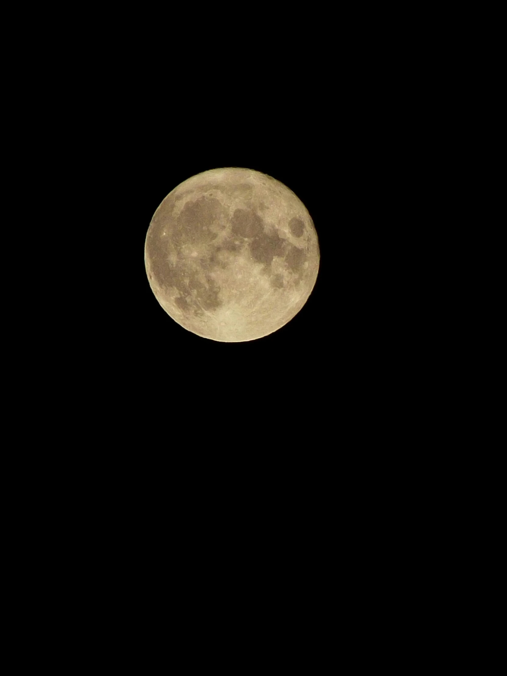 an airplane flying in the air under a large moon