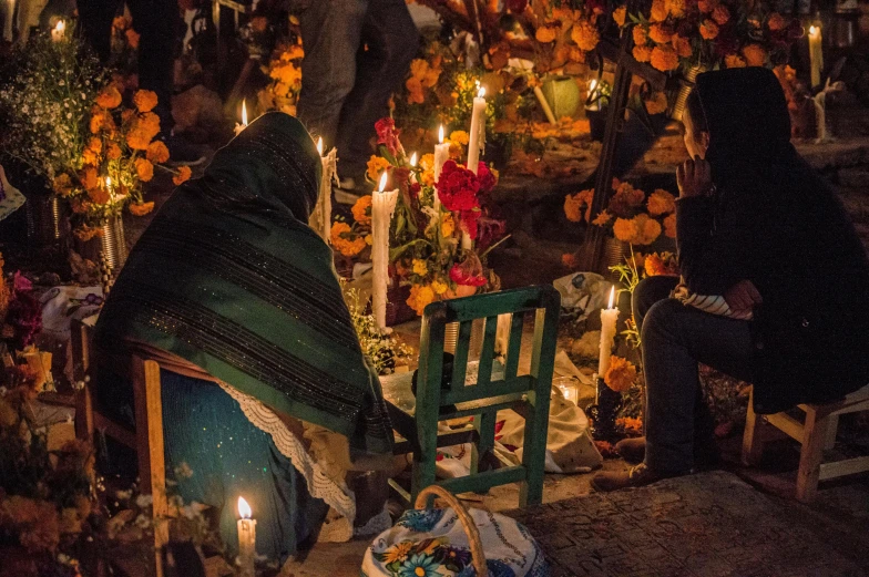 two people sitting on a bench and some candles