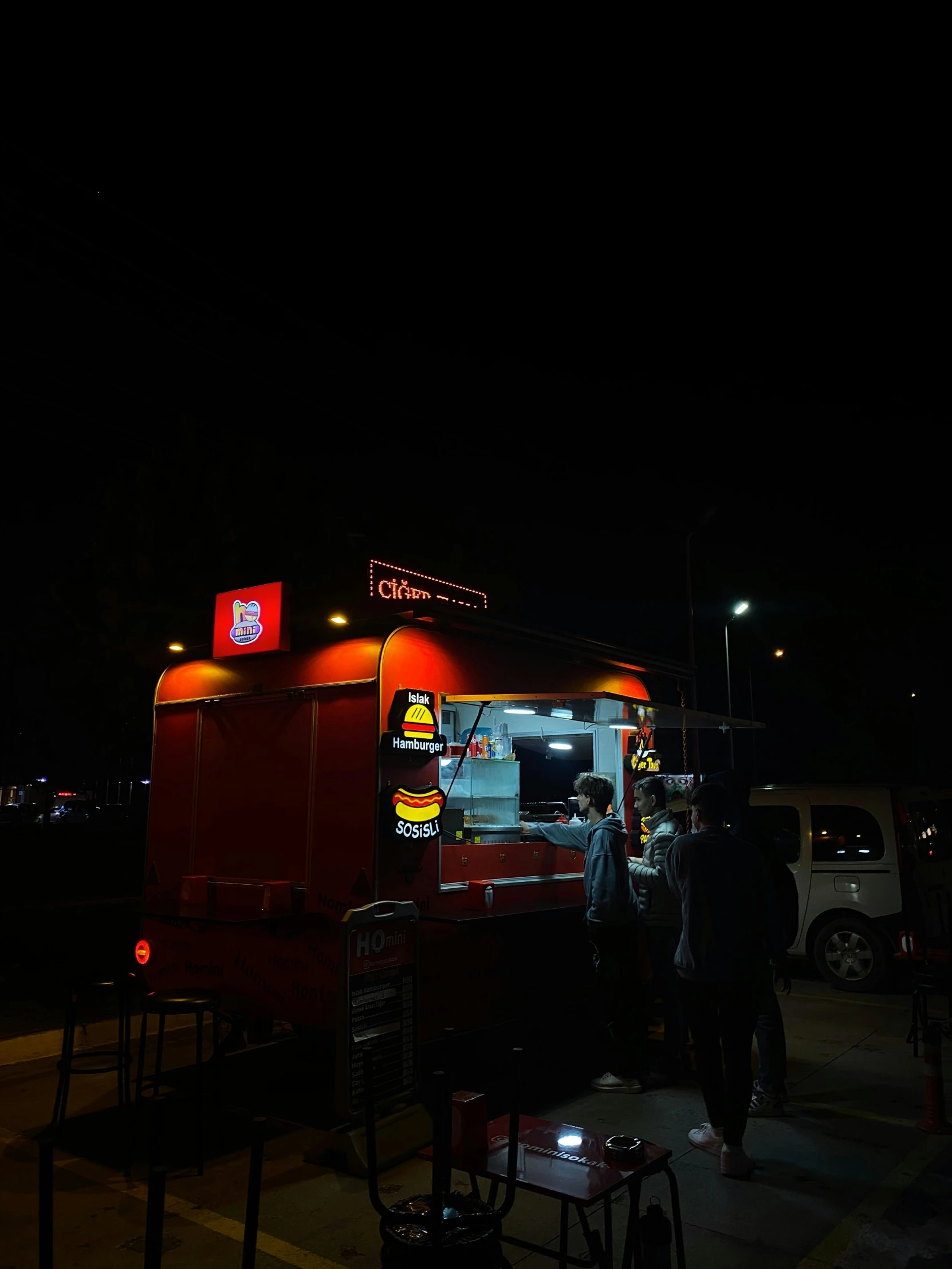 two people are standing near a food truck