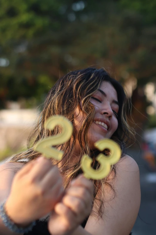 a woman is outside throwing a yellow object in the air