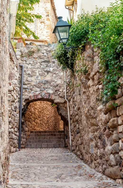 a street with stone walls and a lamp post