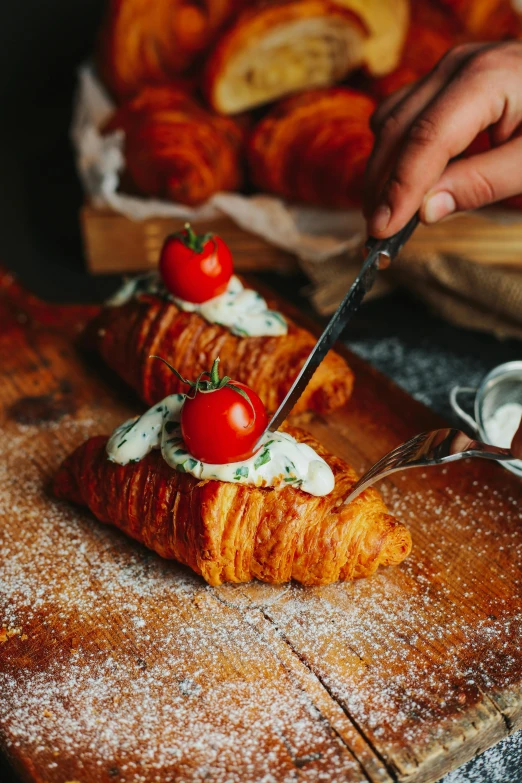 croissant with tomatoes and cream spread on it