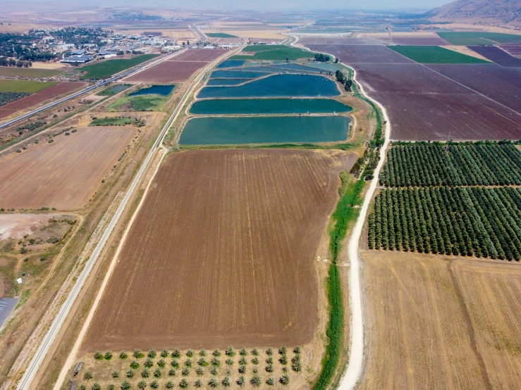 an aerial view of many farm land and a bridge