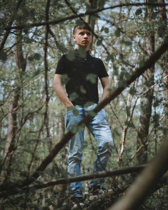 a man is standing in the woods with his hands on his hips