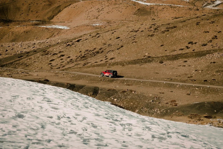 a truck driving down a trail in a snowy landscape