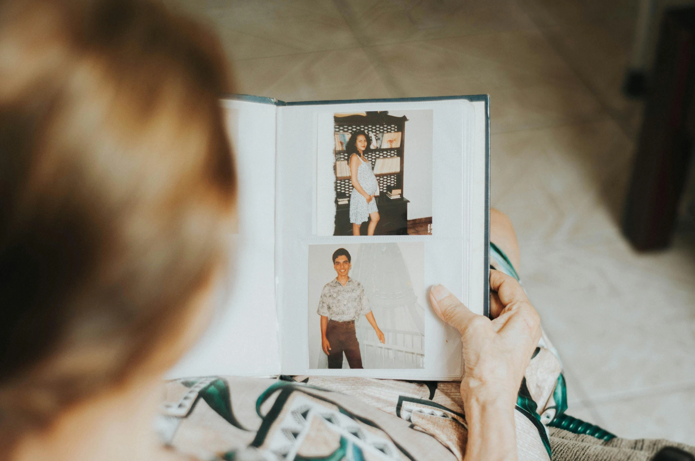 woman is holding an open magazine with pos of people