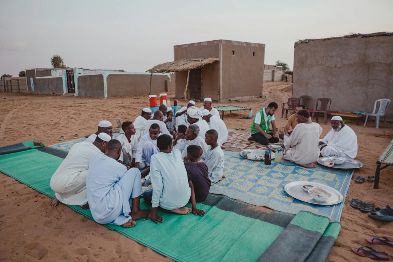 people sit on a blanket and talk to each other