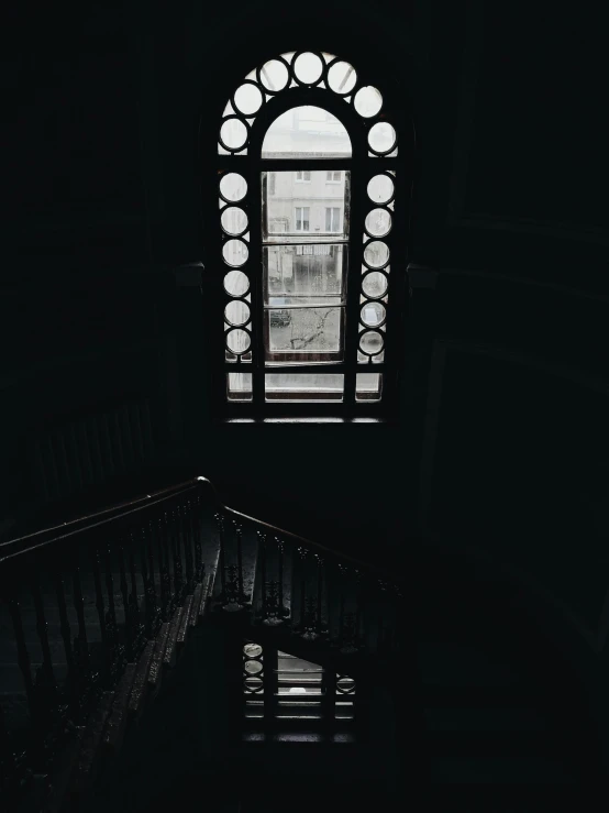 a view of the top of some stairs looking out a window