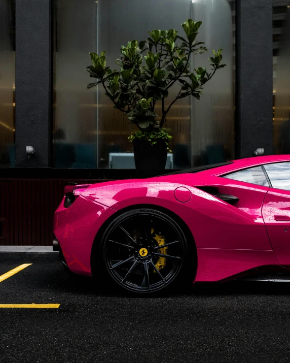 this bright pink sports car is parked in the parking lot