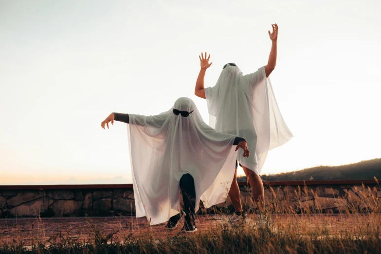 two people dressed in ghostly clothes one is upside down