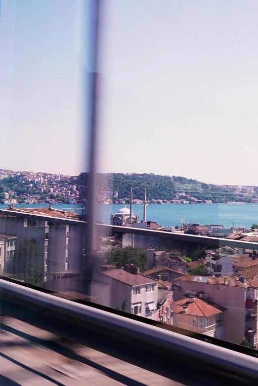 a view from inside of a bus, of buildings and water