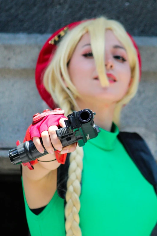 a woman with blonde hair and a hat holding a camera