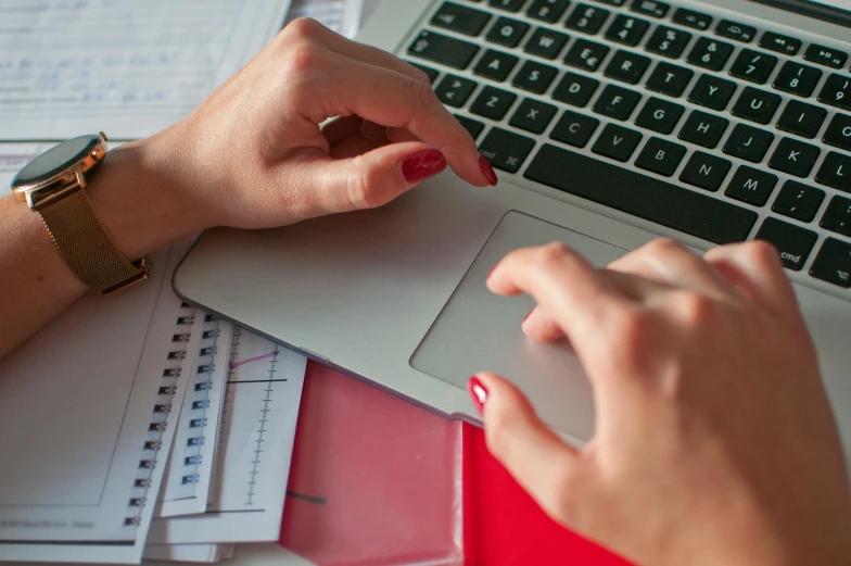 a person is sitting at a desk with a laptop on their hand