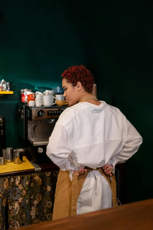 a woman standing in front of an oven in a kitchen