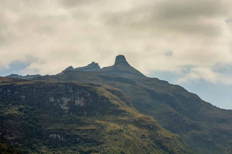 the peak of a mountain stands against cloudy skies