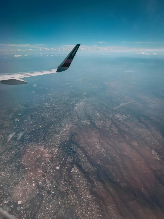 an airplane wing and an airplane over the water