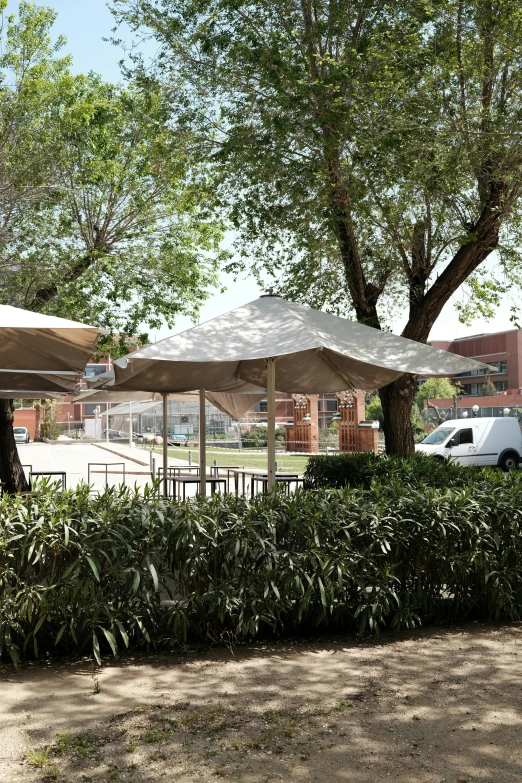 an outdoor area with many tables and some umbrellas