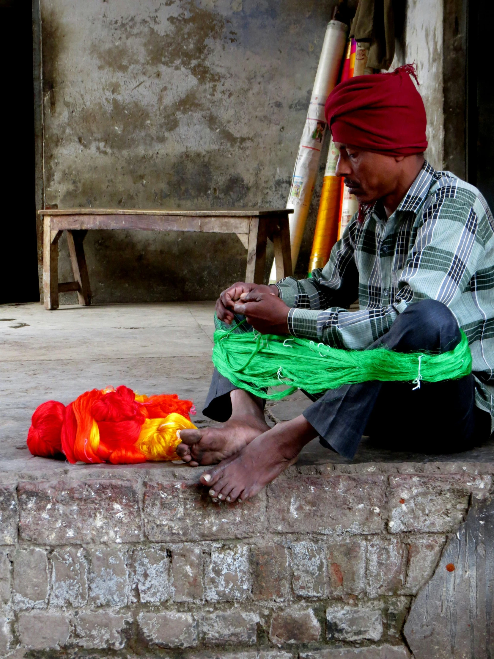 the man is sitting on the curb while making soing orange