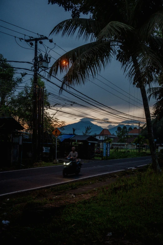 a man is riding on a motor bike under a dark sky