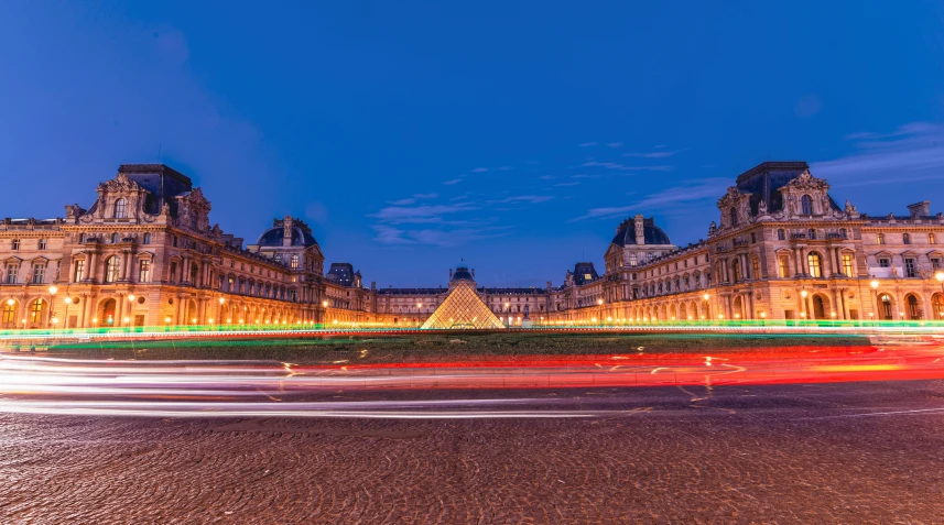 a very ornate building with a long exposure of street lights in the foreground