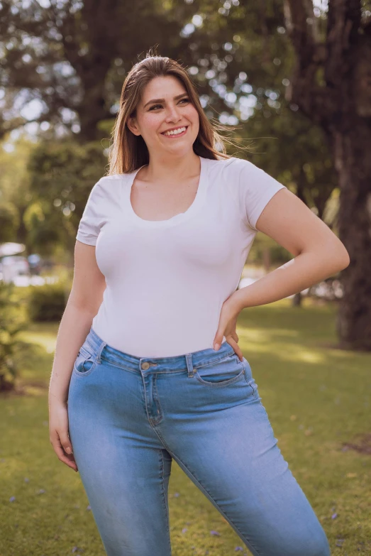 a woman in jeans poses for the camera