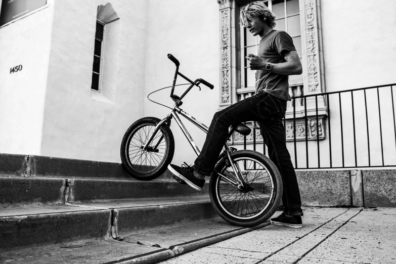 the boy is standing next to his bike