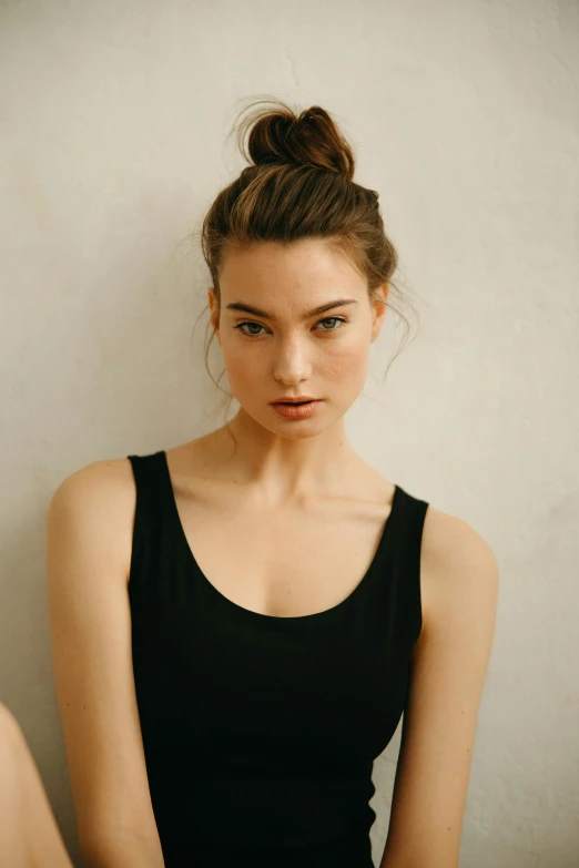 a beautiful young lady in a black top sitting down