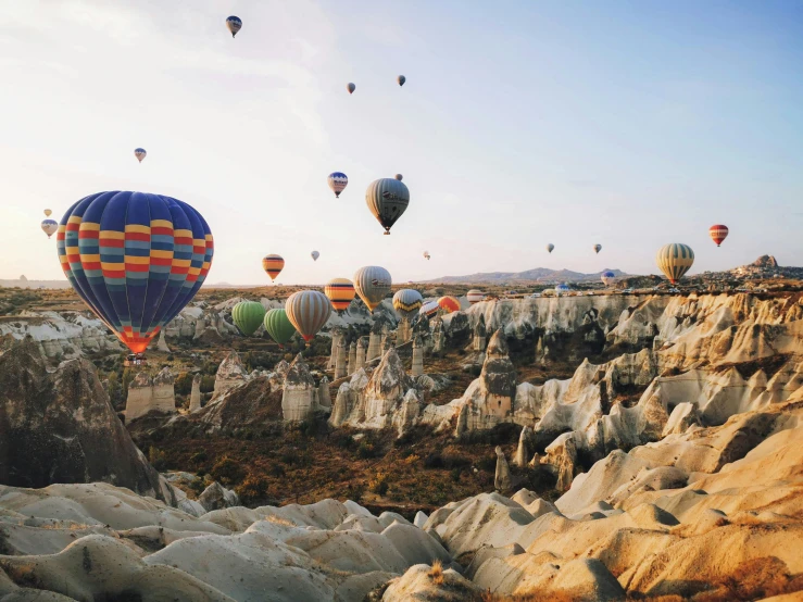 many  air balloons are flying over the mountains