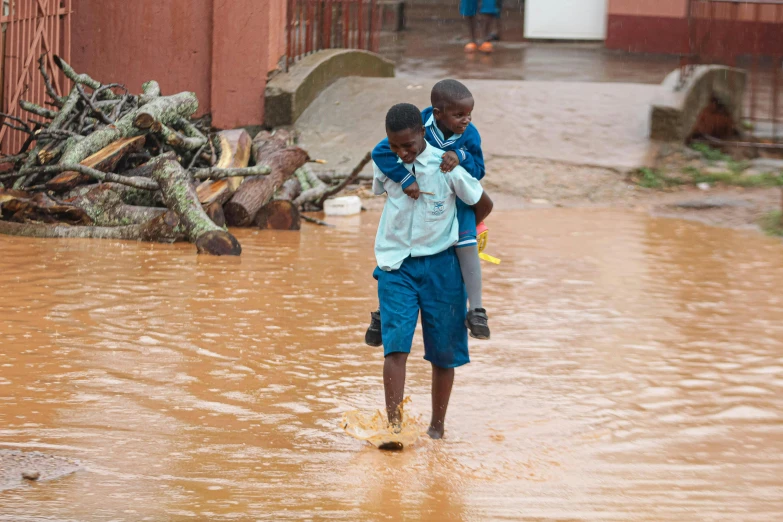 two s walking through flood waters in the city