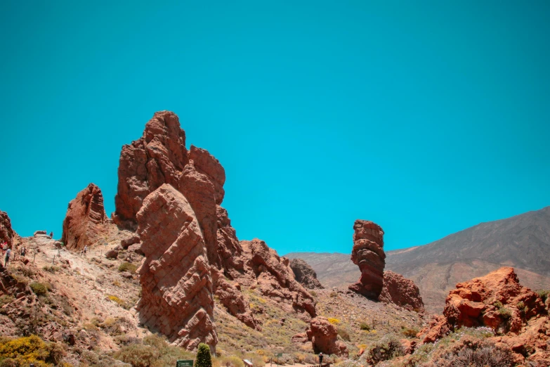 a group of people are standing near a rocky landscape