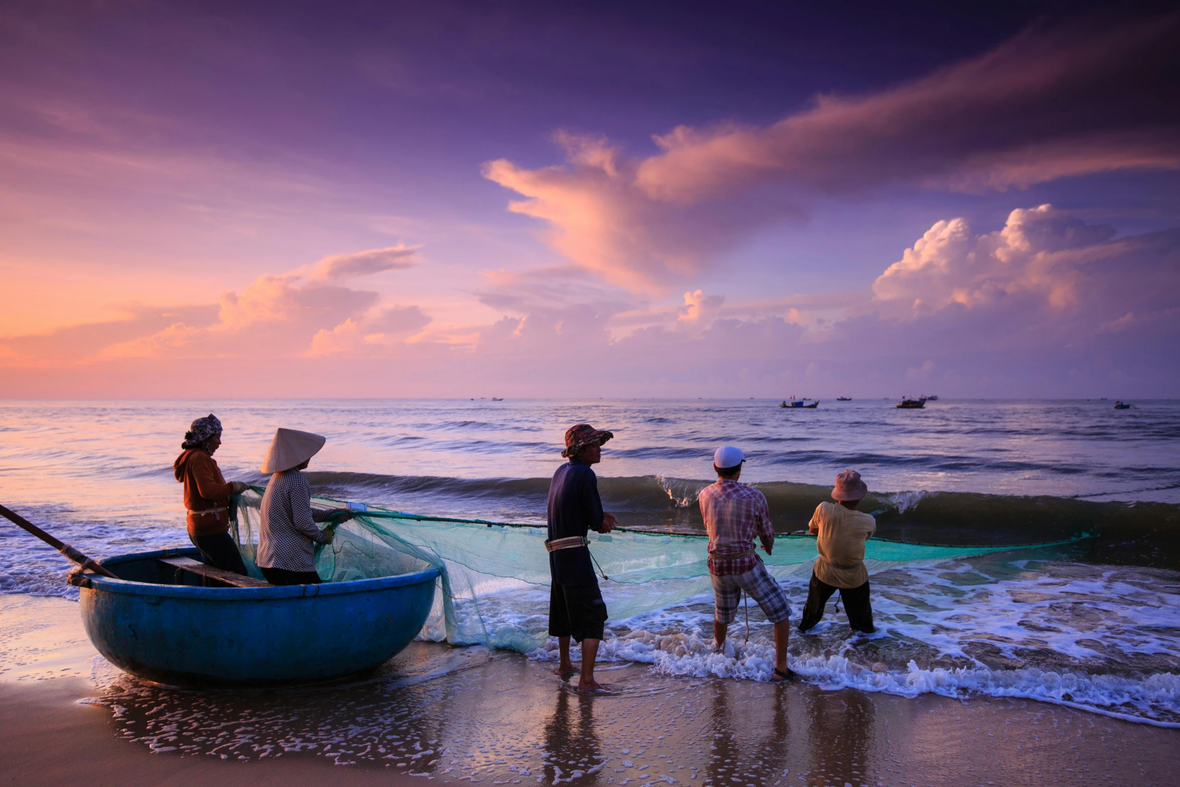 a group of people standing on top of a sandy beach