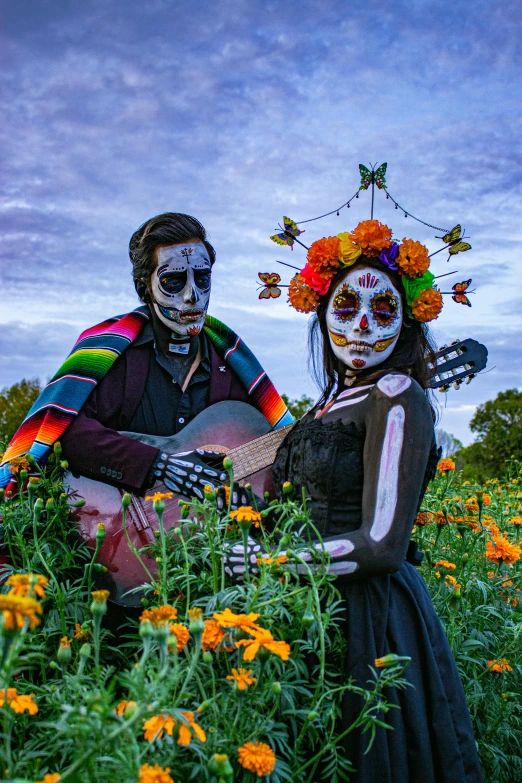 two men and women are sitting in a field of flowers