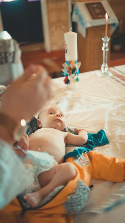 two baby girls laying on the bed and being held up