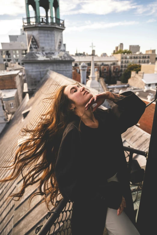 a woman with long hair standing on top of a roof