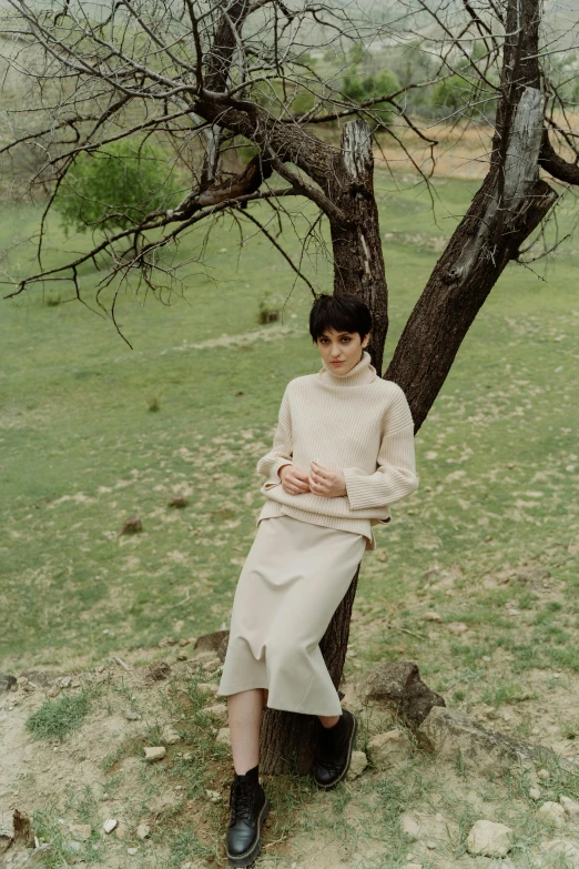 a woman sitting in front of a tree
