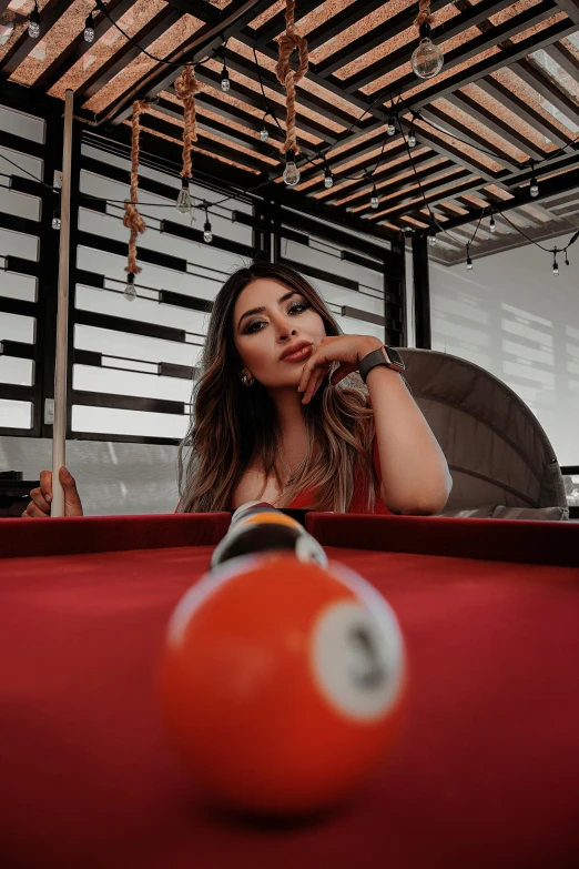 a woman in a room next to a pool table