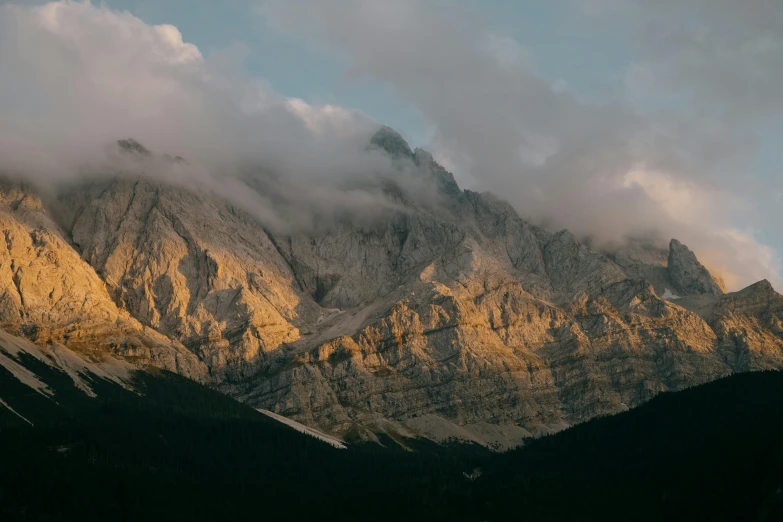 a mountain with clouds and a horse in the foreground