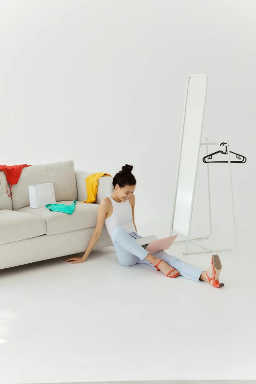 a woman sits on the floor looking at herself in the mirror