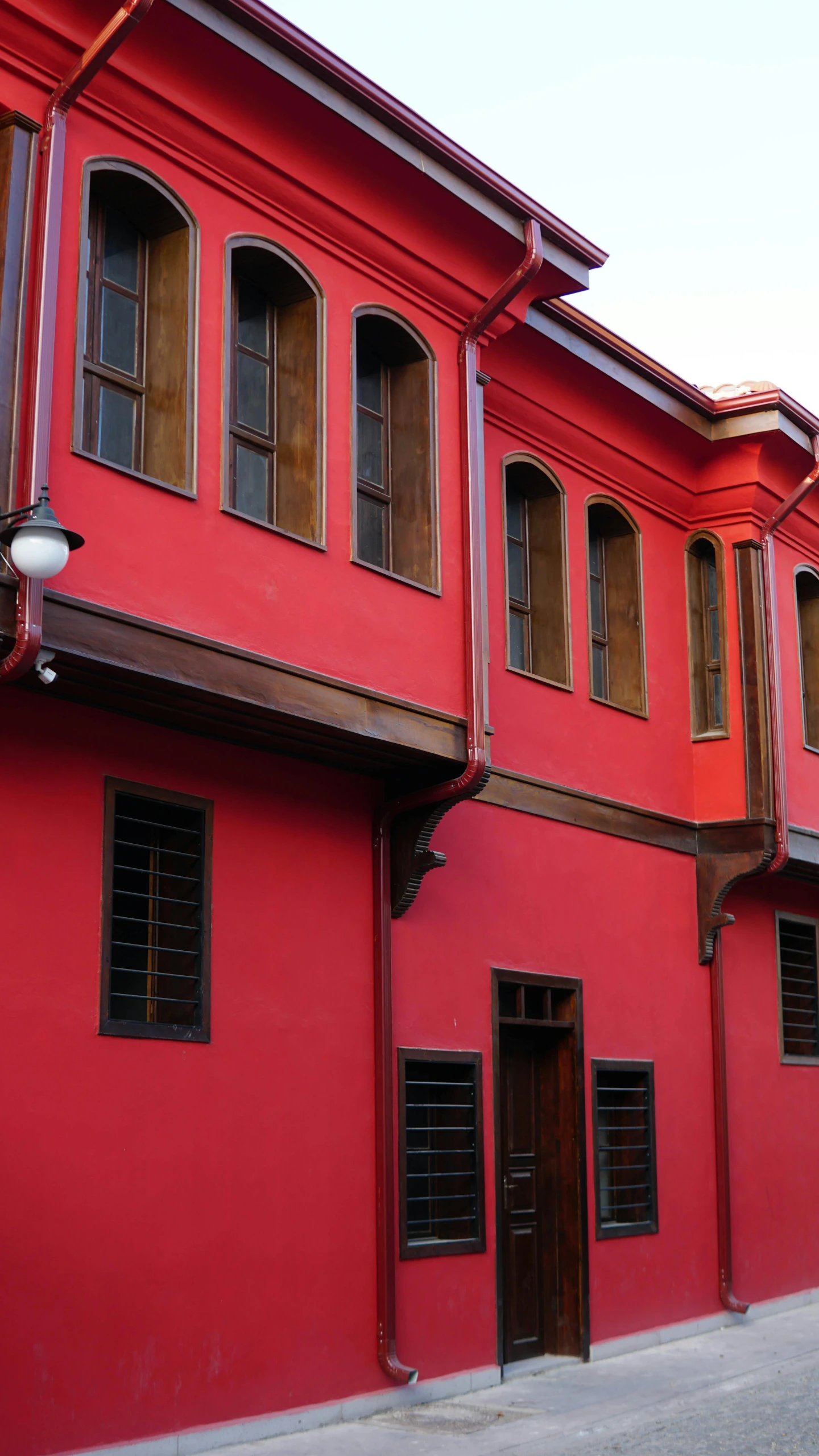 the side of a building with red walls and shutters