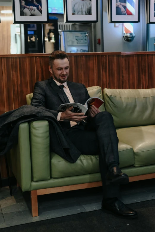 a man with beard sitting on a green couch